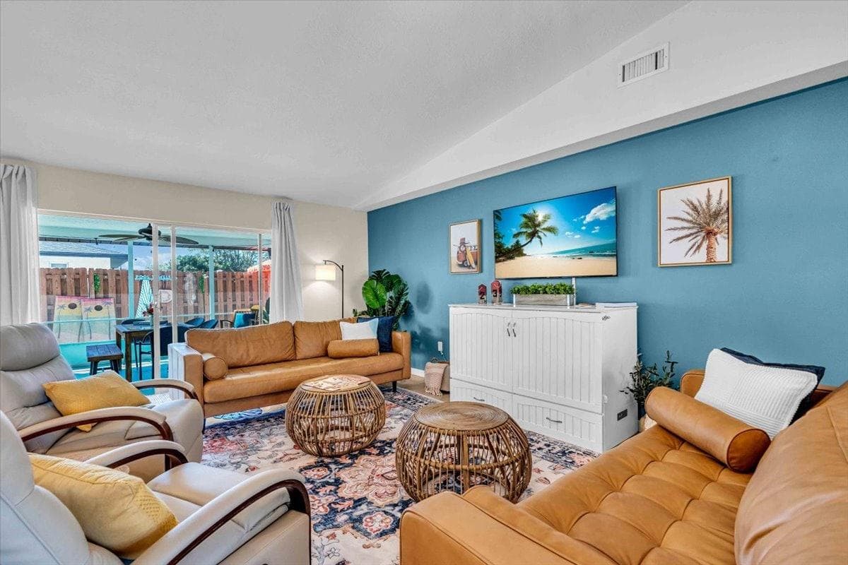 Living Room: Bright, tropical-inspired space with comfy seating and a view of the pool area!